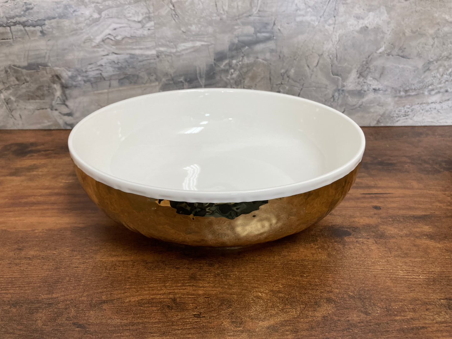 Serving white Salad bowl round with gold color hammer pattern. Home decor table top.