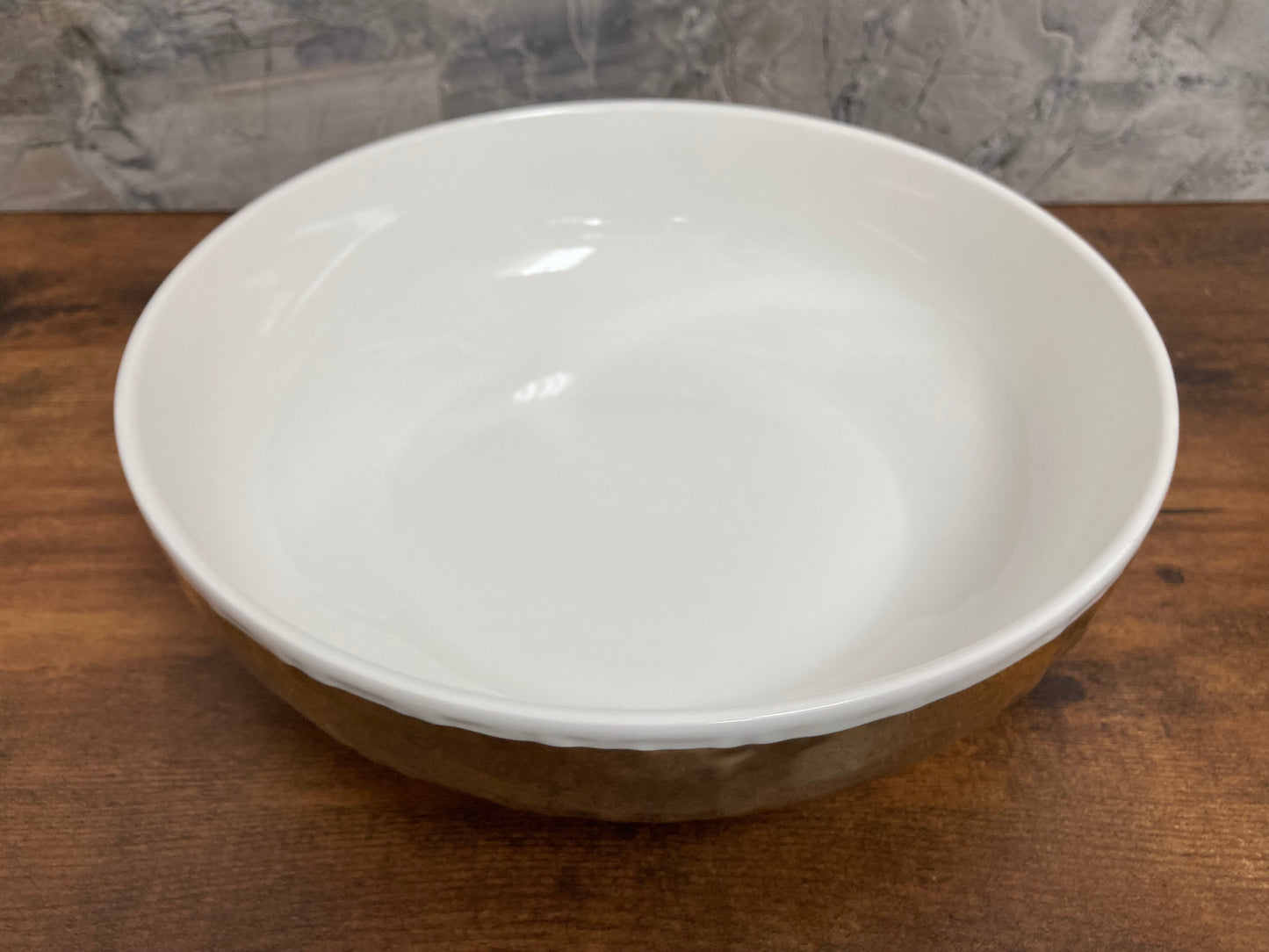 Serving white Salad bowl round with gold color hammer pattern. Home decor table top.
