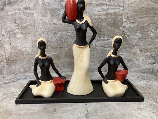 Figurine 3 pcs beautiful African ladies statute ,with a black wooden base . Stylish home decor ,vibrant beige colors .