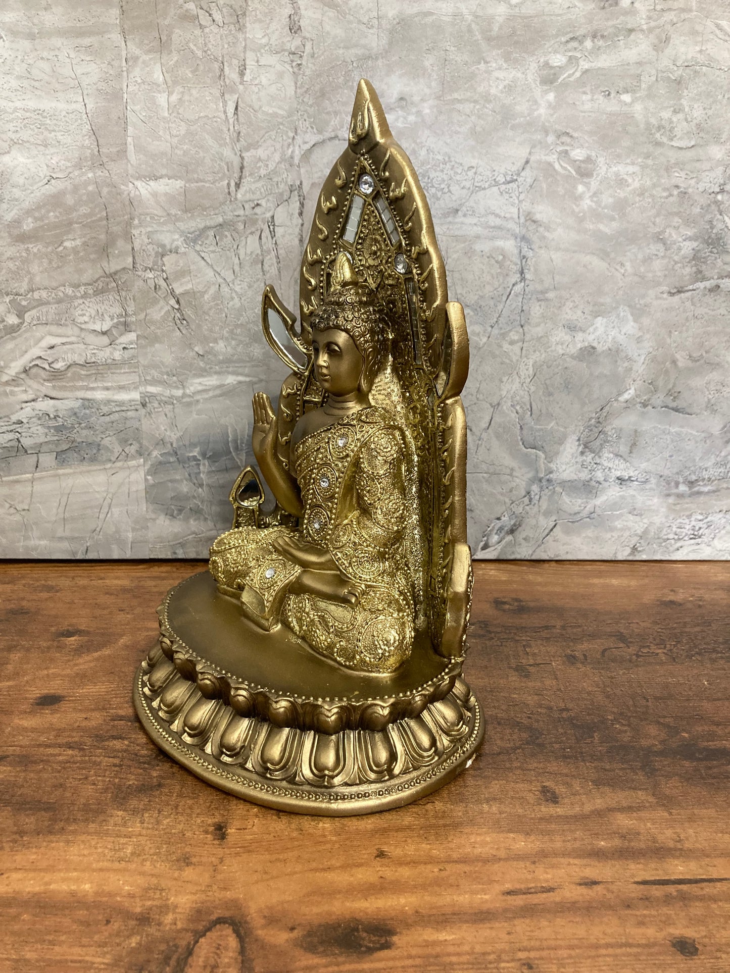 Golden Buddha statue meditation faith with stones and mirrors.