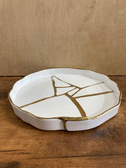 Serving white ceramic plater plate tray round with gold color pattern. Home decor table top.